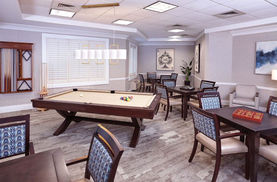 A modern game room featuring a shuffleboard table and seating area.