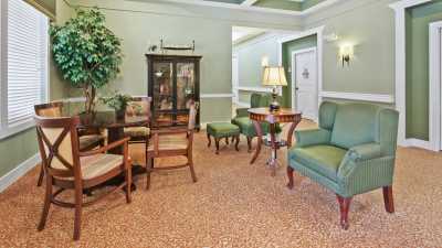 A classic living room with green walls and comfortable seating.