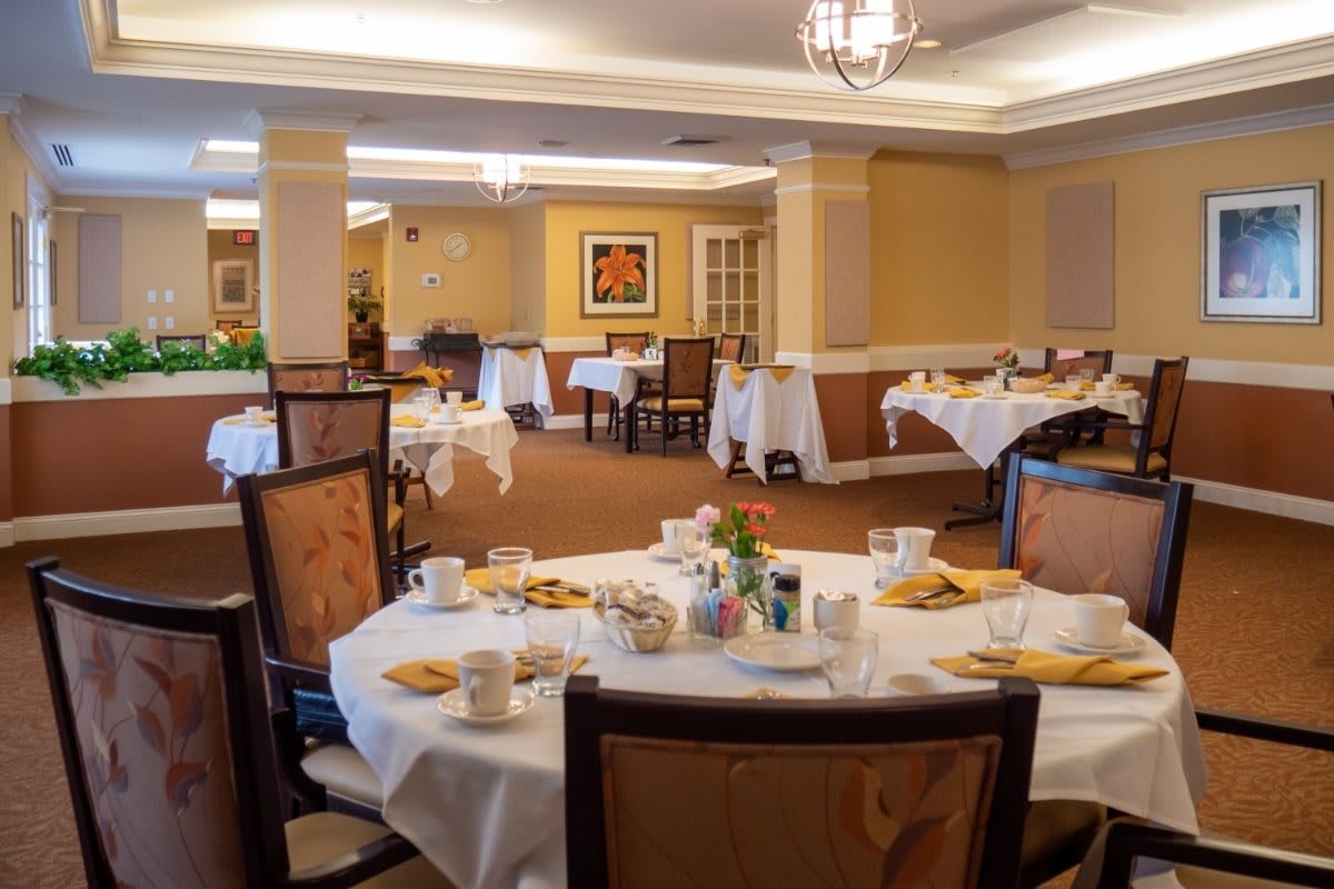 An elegantly decorated dining room with several tables set for meals.