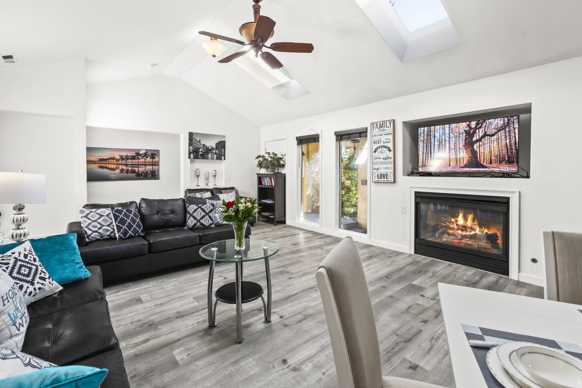 A modern living room with a cozy fireplace, stylish artwork, and comfortable seating.
