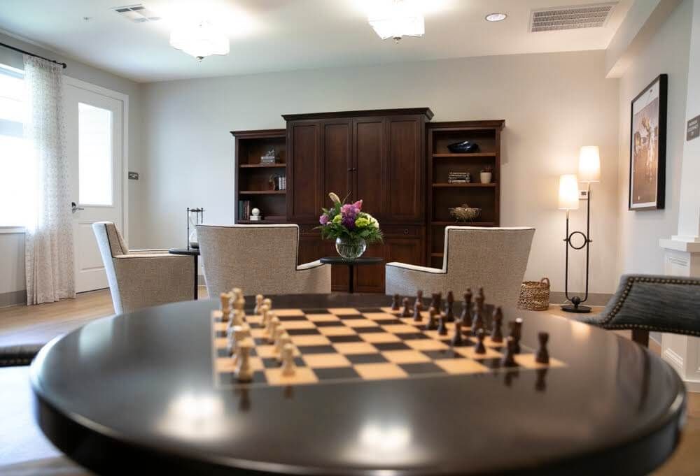 A cozy living room with a chess set on the table and comfortable seating nearby.