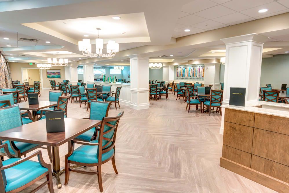 A spacious and elegantly designed dining area with tables, chairs, and chandeliers.