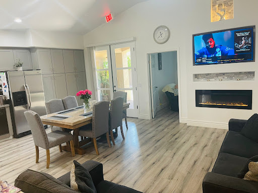 A cozy and modern living space featuring a dining area, a comfortable sofa, and a wall-mounted television.