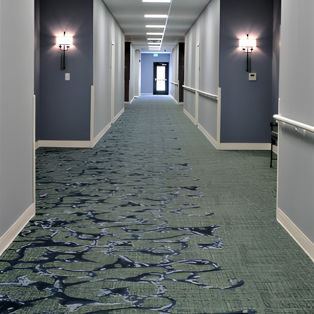 A long, carpeted hallway with wall lights illuminating the corridor.