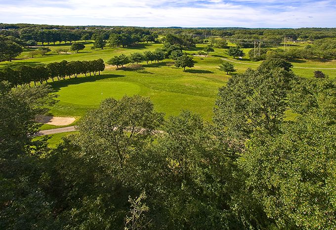 A scenic view of a lush golf course with vibrant greenery and well-manicured landscapes.