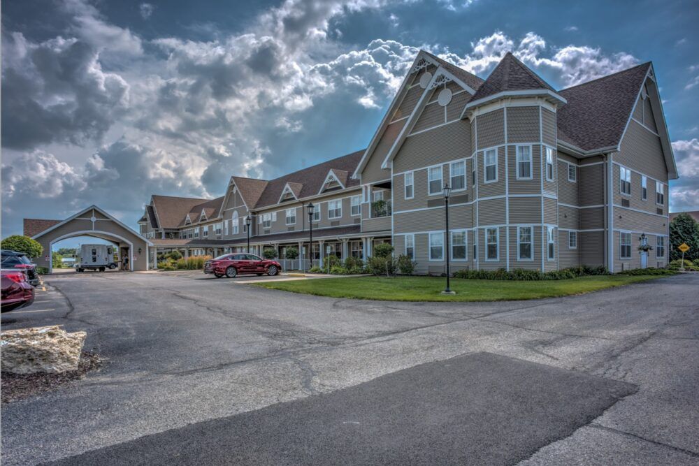 A large, multi-story building with a cloudy sky in the background.
