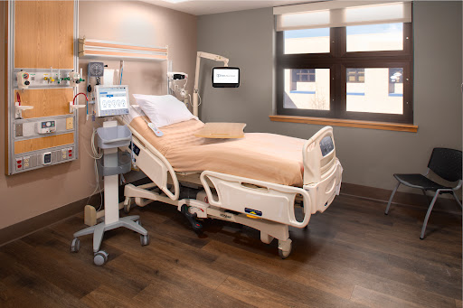 A well-equipped patient room in a modern hospital, featuring a medical bed and essential monitoring equipment.