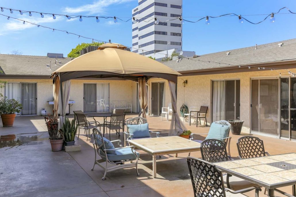 A cozy patio with a gazebo and comfortable seating in an urban setting.