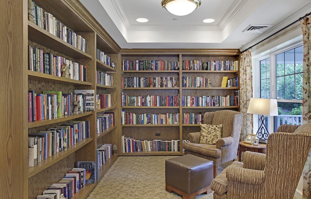 A cozy library corner with bookshelves filled with books and a comfortable armchair for reading.