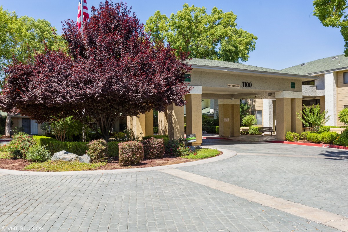 A welcoming hotel entrance with well-maintained landscaping and a paved driveway.