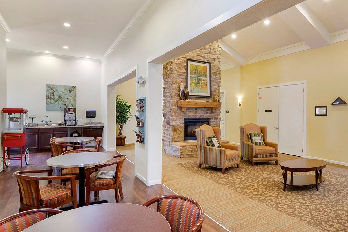 A cozy living space featuring a fireplace, comfortable seating, and dining tables.
