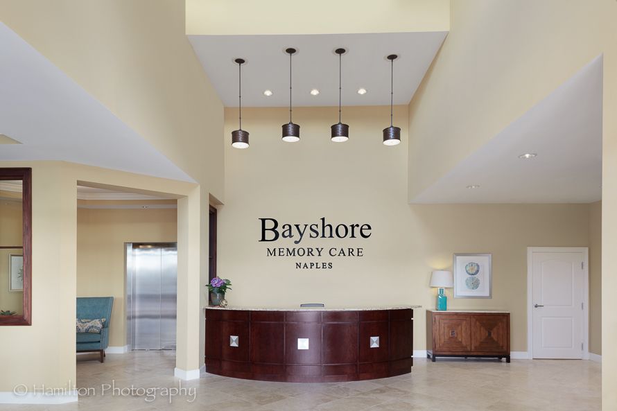 Lobby area of Bayshore Memory Care with a reception desk and decorative lighting.