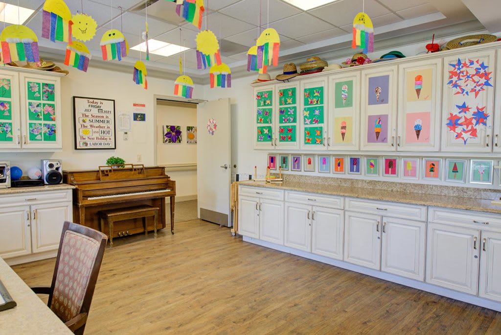 A colorful classroom adorned with children's artwork and decorations, featuring a piano.