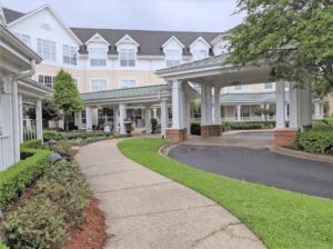 A well-maintained building with a pathway leading to the entrance, surrounded by greenery.