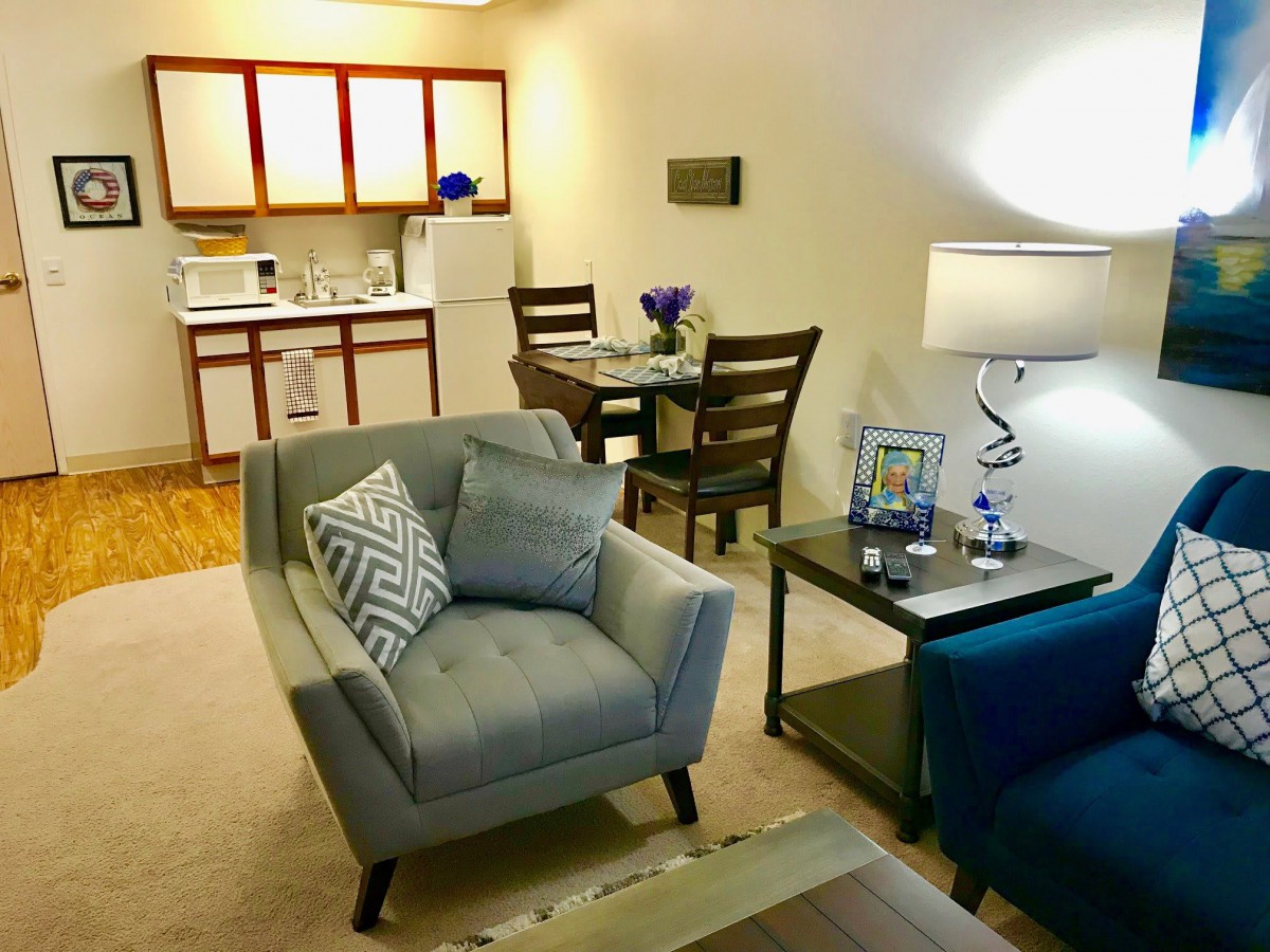 A cozy apartment living area with comfortable seating and a kitchenette.