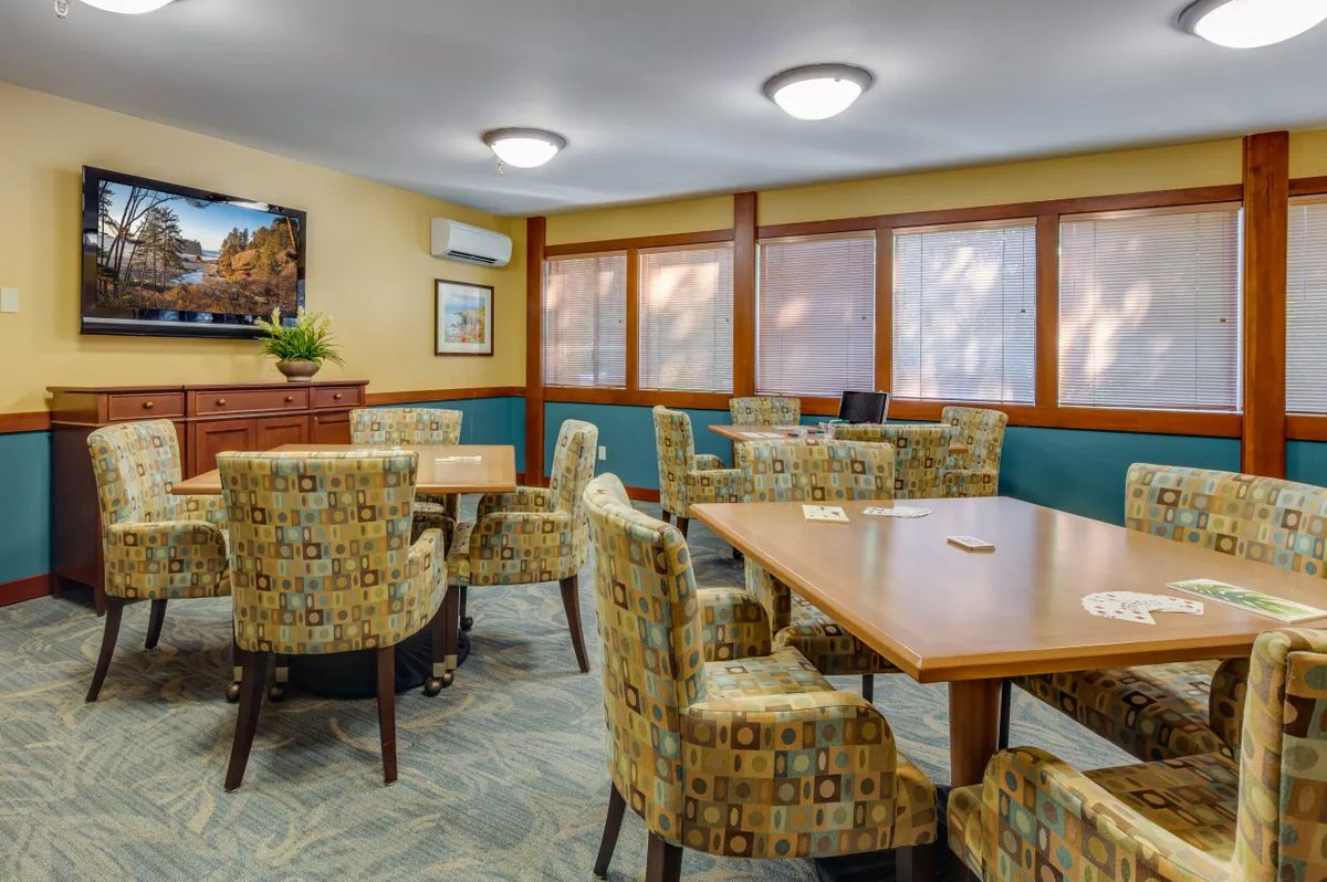 A well-appointed meeting room featuring patterned chairs, wooden tables, and soft lighting.