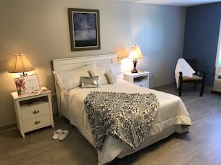 A cozy bedroom with a neatly made bed, soft lighting, and a comfortable ambiance.