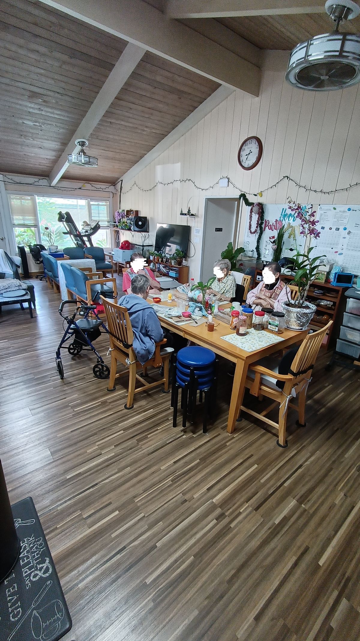 A group of elderly individuals engaged in a crafting activity around a table in a cozy room.