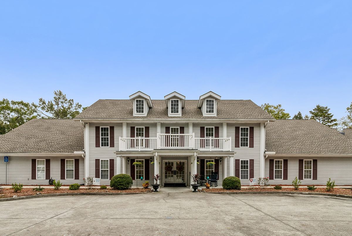 A large colonial-style mansion with a symmetrical facade and multiple windows.
