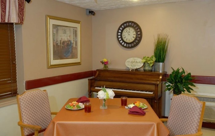 A cozy dining area with a piano, complete with a decorated table and wall art.