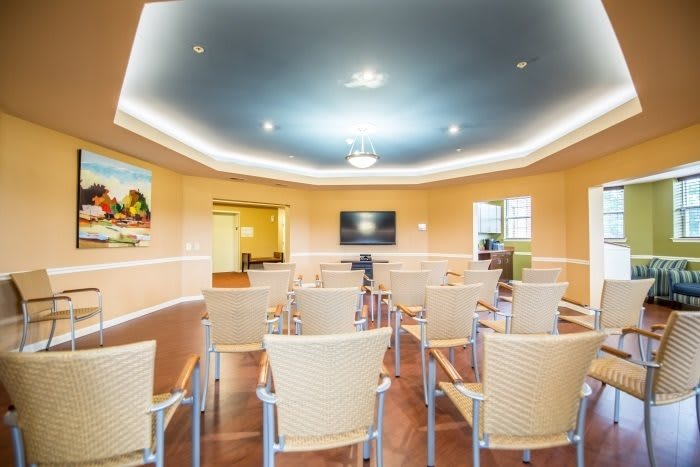 A modern conference room set up with chairs facing a television.
