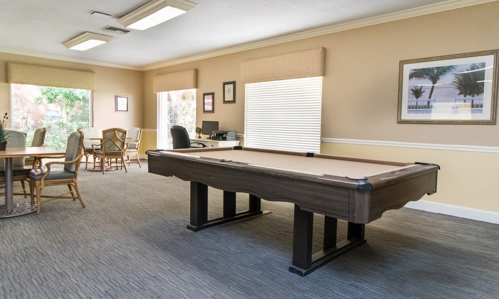 A spacious game room featuring a pool table and an office area.