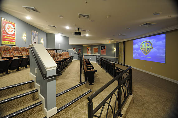 A spacious home theater with tiered seating and a large screen for an immersive movie experience.