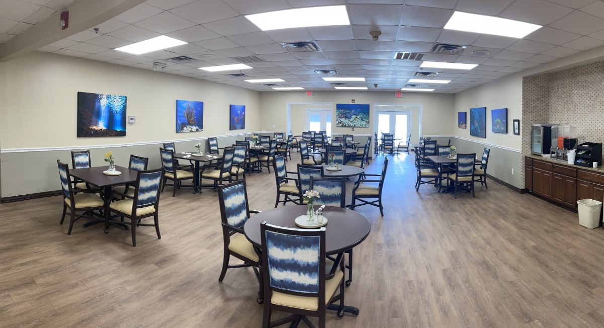 A spacious dining hall with neatly arranged tables and chairs.