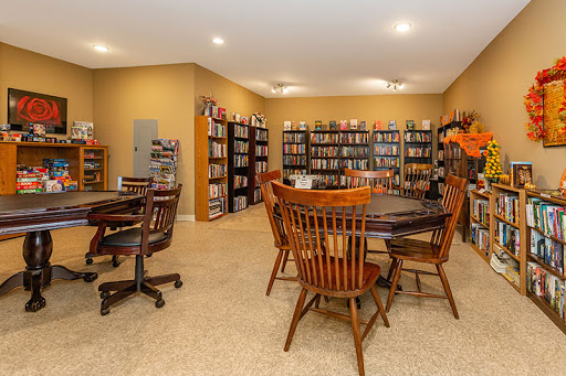 A cozy library space featuring shelves filled with books and comfortable seating for reading.
