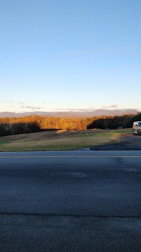 A serene view of rolling hills and mountains bathed in the warm glow of sunset.