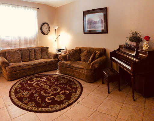 A cozy living room featuring comfortable seating, a piano, and decorative elements.