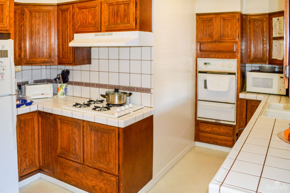 A kitchen with wooden cabinets, a stovetop, and an oven.
