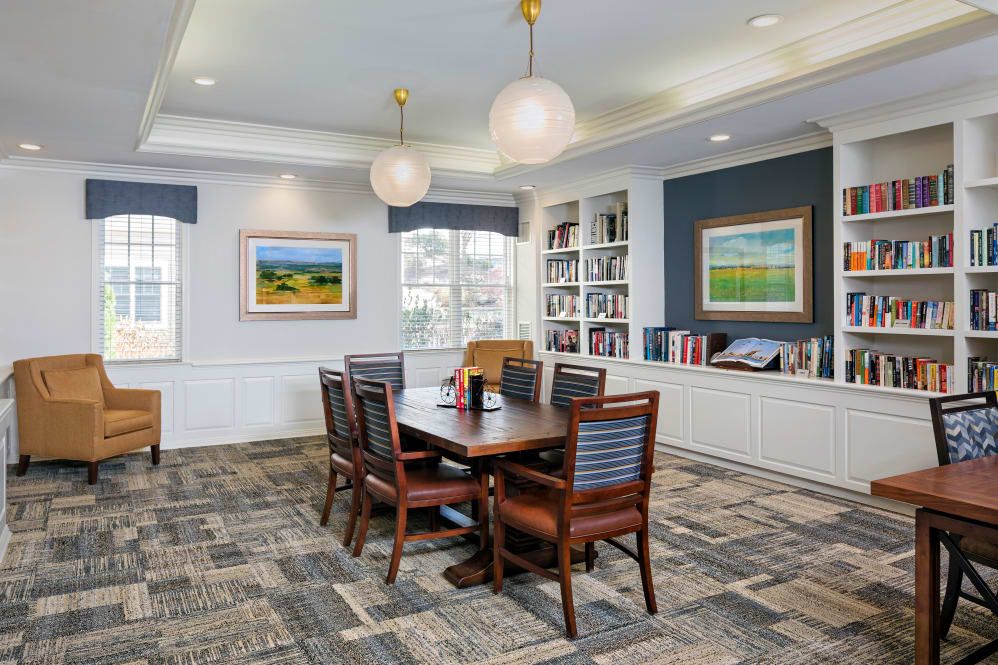 A well-decorated meeting room featuring a conference table, bookshelves, and framed artwork.