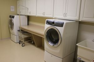 A tidy laundry room featuring a modern washing machine and organized shelving.