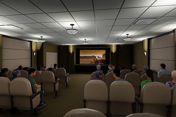 An indoor theater with an audience watching a movie.