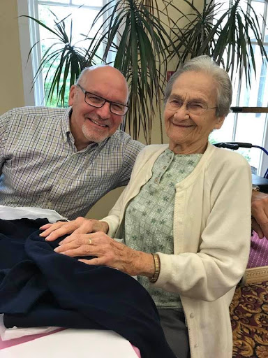 A heartwarming moment between a smiling elderly woman and her companion, sharing joy and connection.