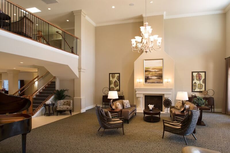 Elegant hotel lobby with seating area, chandelier, and fireplace.