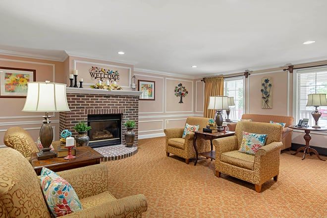 A cozy living room featuring a brick fireplace, comfortable seating, and traditional decor.