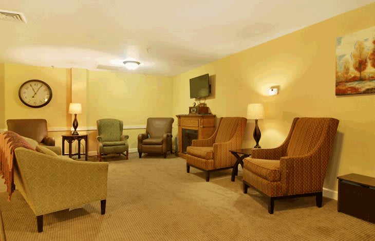 A cozy living room with multiple seating options, a television, and a fireplace.