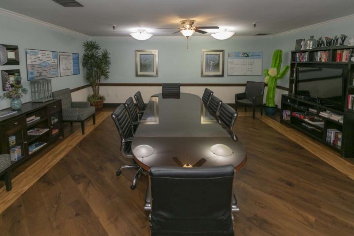 A professional conference room with a long meeting table and chairs.
