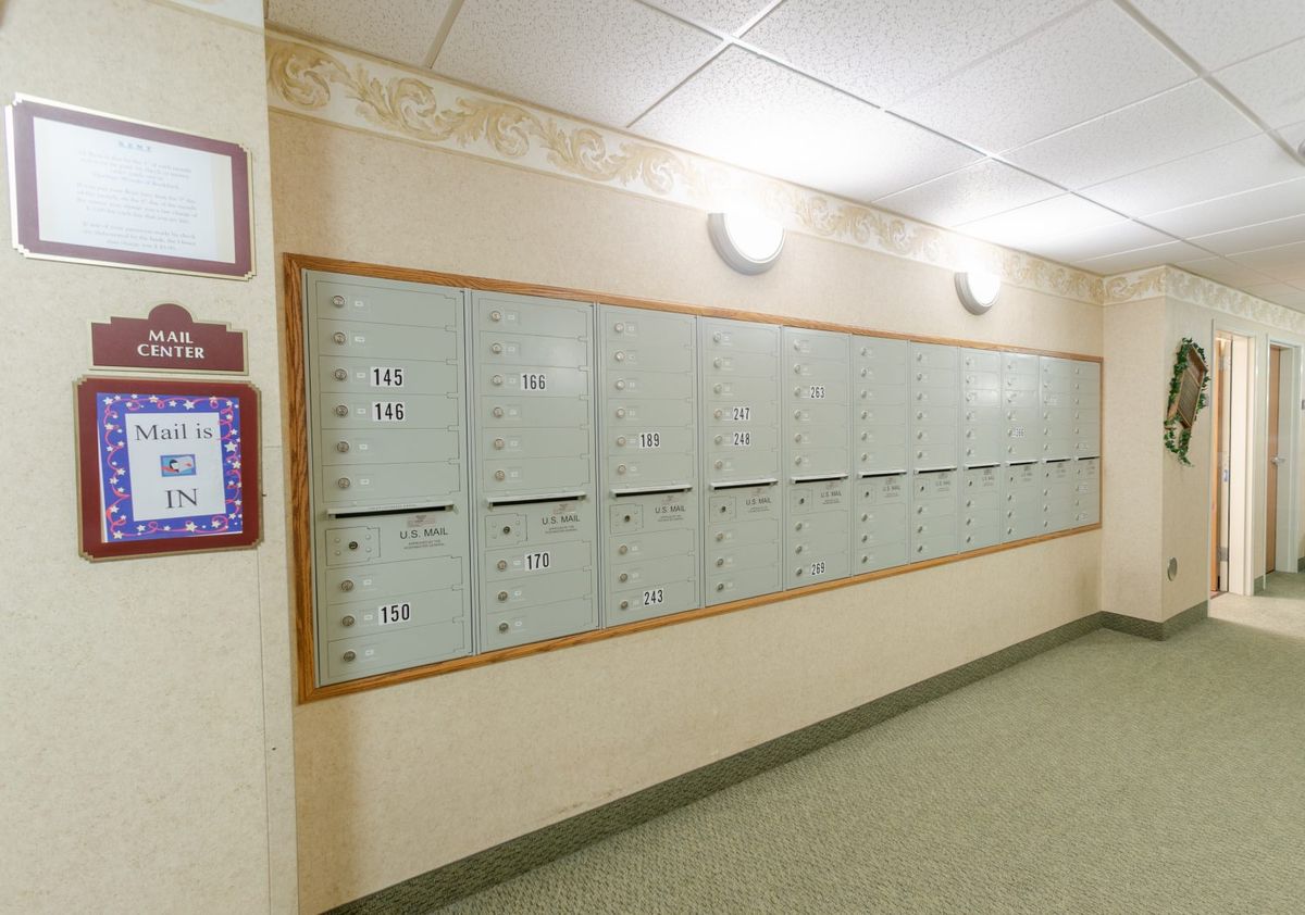 A row of mailboxes in the hallway of an apartment building.