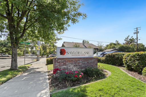 A welcoming sign for a residential community, surrounded by well-maintained landscaping and clear blue skies.