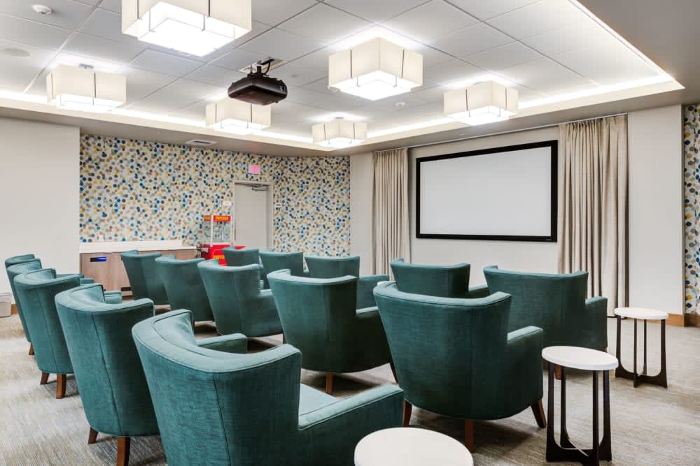 A modern theater room with comfortable seating and a large projector screen.