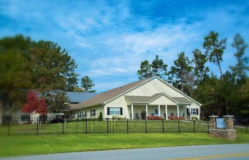 A well-maintained residential building set against a picturesque sky, surrounded by lush greenery.