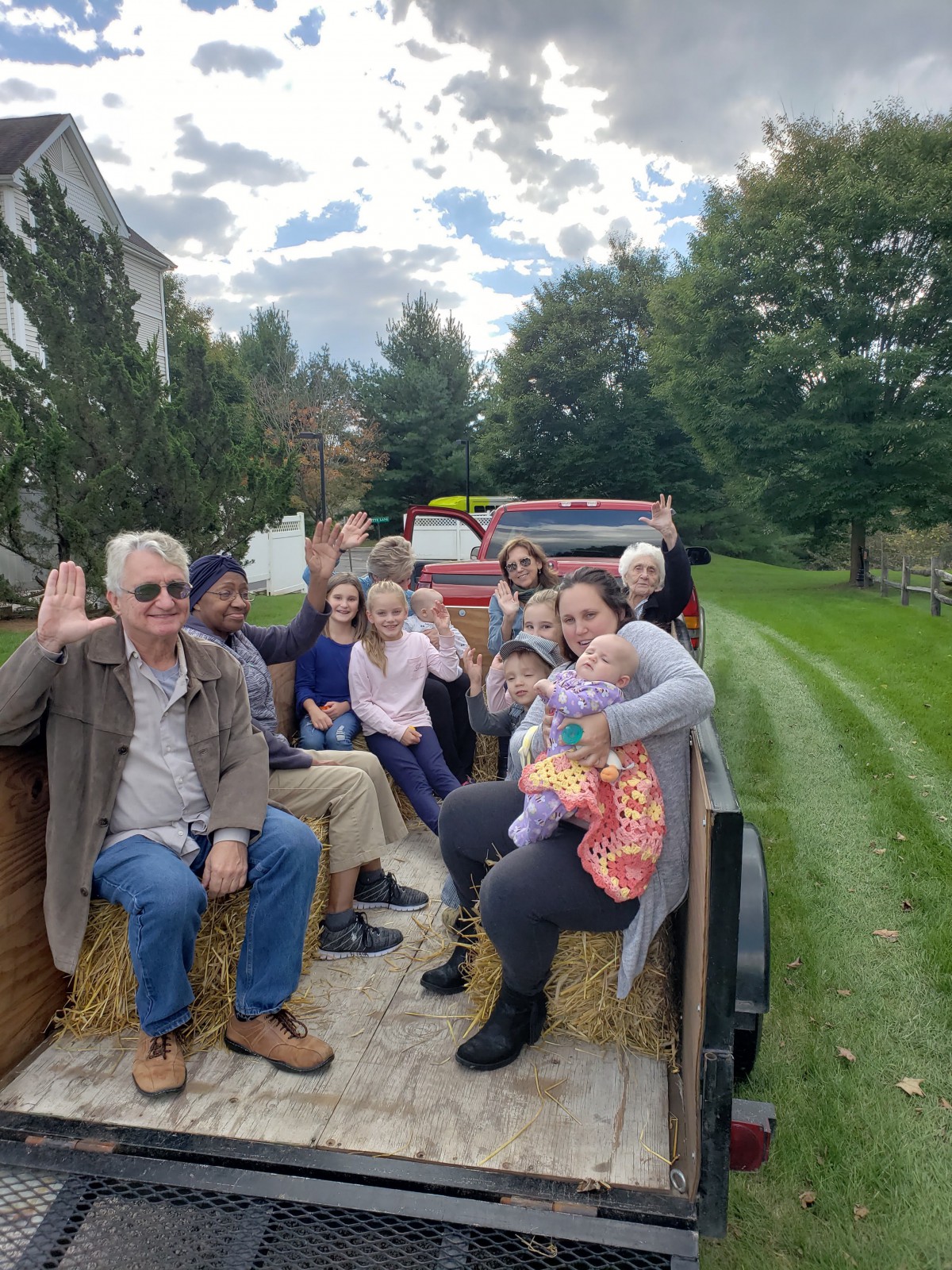 A group of people enjoying a hayride through scenic surroundings.