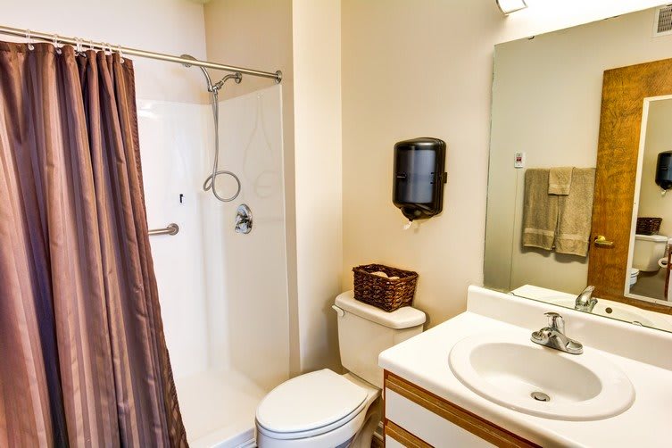 A clean and organized bathroom featuring a shower, sink, and toilet.