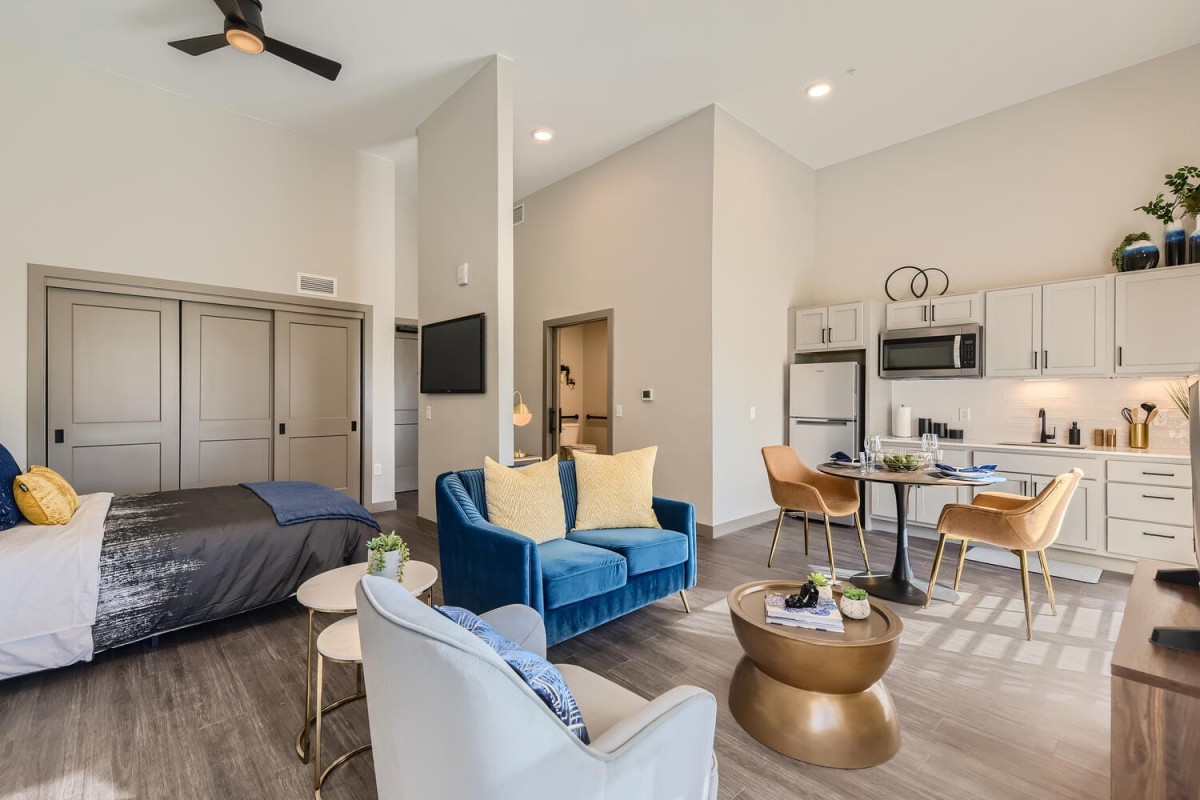 A modern, open-concept living space with stylish furniture and an integrated kitchen.