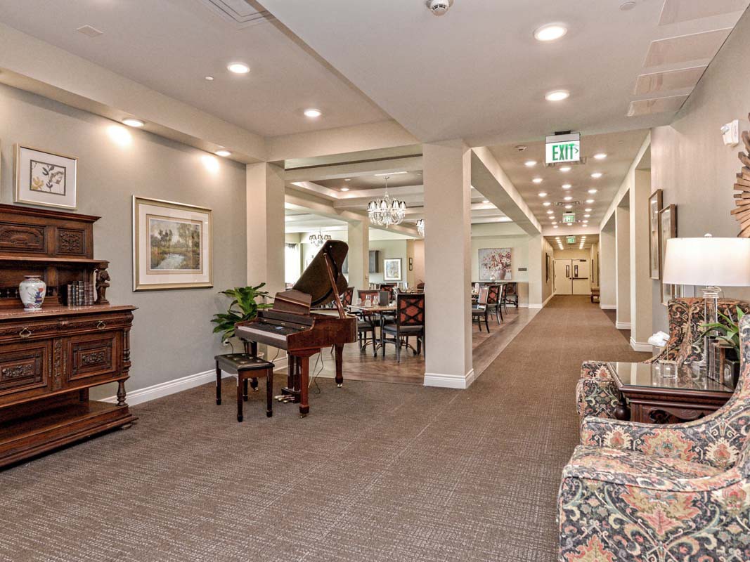 A well-decorated hallway featuring a grand piano and elegant furniture.
