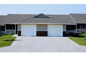 A suburban duplex with two garages and a wide driveway.