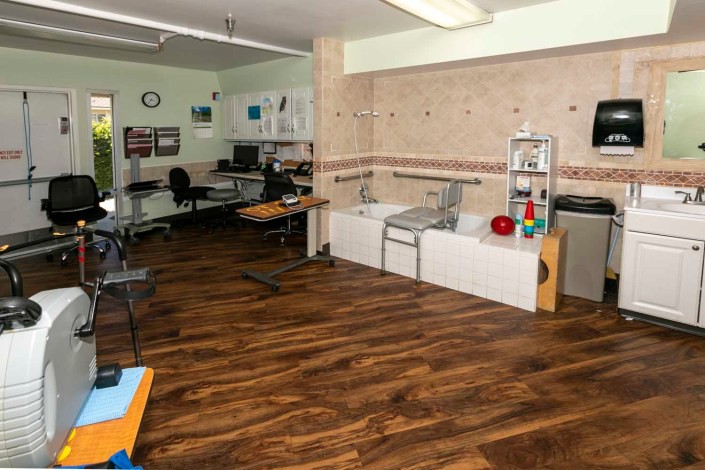 A therapy room in a medical clinic equipped with rehabilitation devices and workspace.
